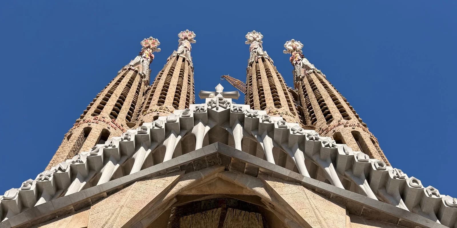 Close-up of the Sagrada Familia's finished towers against a clear blue sky in Barcelona